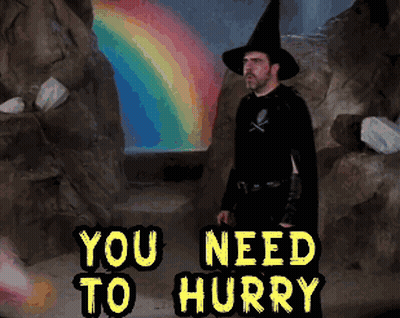 Man In Witch Costume Standing In Front Of Rainbow Saying You Need To Hurry GIF