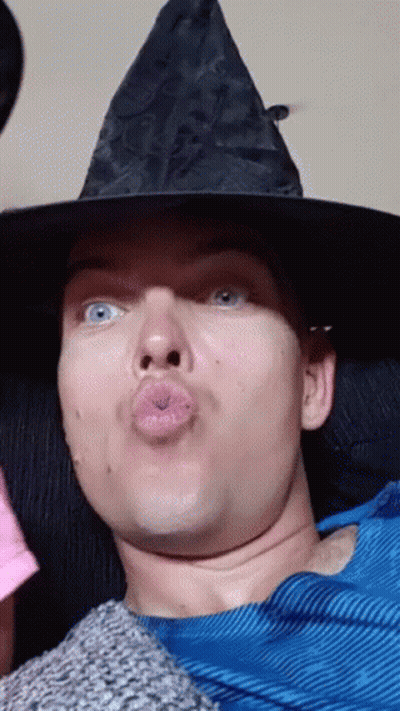 Man In Witch Hat Blowing Kiss GIF