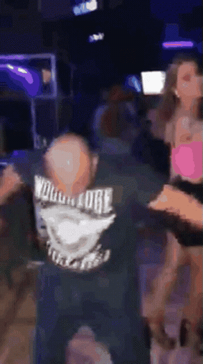 Man In Wolverine Shirt Dancing In Dark Room GIF