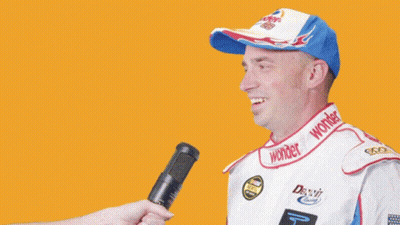 Man In Wonder Hat Being Interviewed GIF