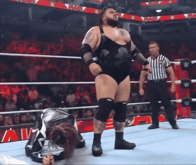 Man In Wrestling Ring With Referee And Sign Saying A GIF