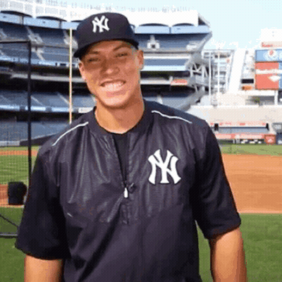 Man In Yankees Jacket And Hat Smiling GIF