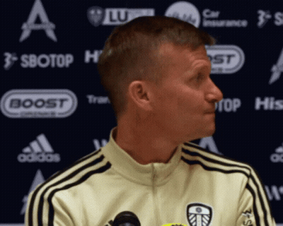 Man In Yellow Adidas Jacket In Front Of Sbotop Banner GIF