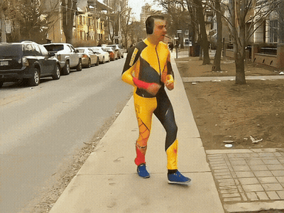 Man In Yellow And Black Jumpsuit With Headphones GIF