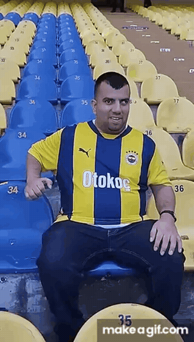 Man In Yellow And Blue Otokoc Shirt Sitting In Stadium GIF