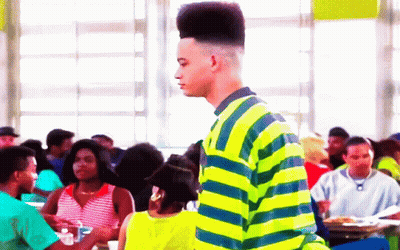Man In Yellow And Blue Striped Shirt In Crowd GIF