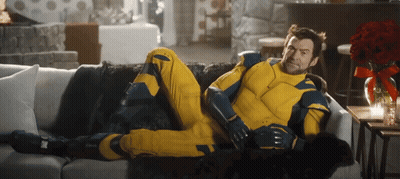Man In Yellow And Blue Suit Laying On White Couch GIF