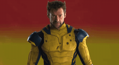 Man In Yellow And Blue Superhero Costume Holding Claws Out GIF
