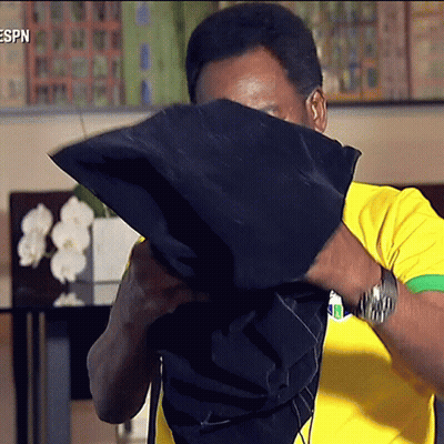 Man In Yellow And Green Shirt Covering Face GIF