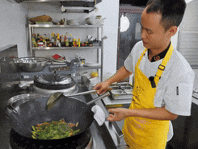 Man In Yellow Apron Cooking On Stove GIF