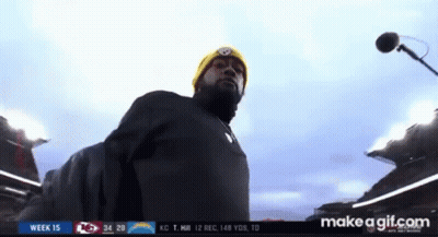 Man In Yellow Beanie At Microphone In Stadium GIF