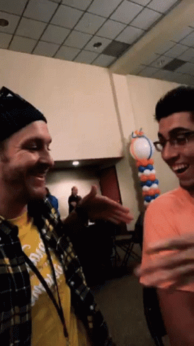 Man In Yellow 'California' Shirt Talking To Another GIF