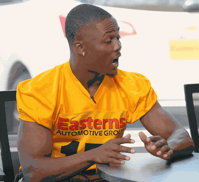 Man in Yellow Easterns Automotive Group Jersey Sitting at Table