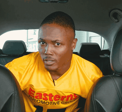 Man In Yellow Easterns Automotive Group Shirt In Back Seat GIF
