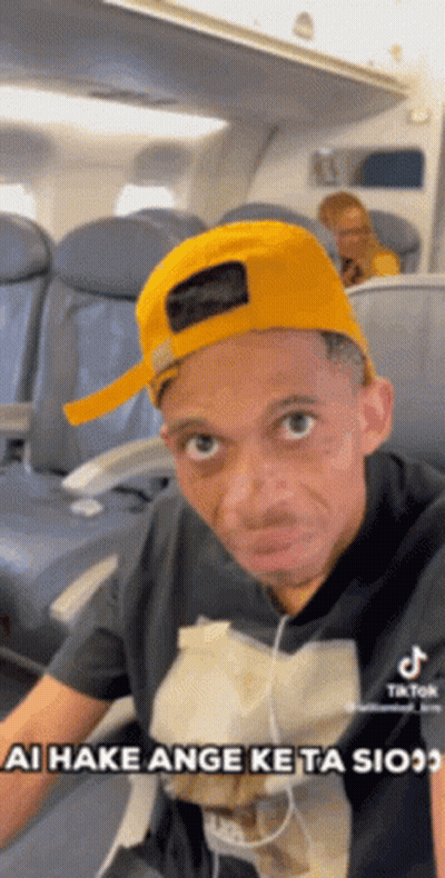 Man In Yellow Hat Sitting On Airplane GIF