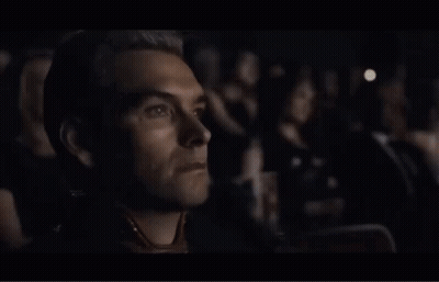 Man In Yellow Hazmat Suit Walking In Crowd GIF