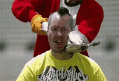 Man In Yellow Heavy Metal Shirt Being Shaved By Santa GIF