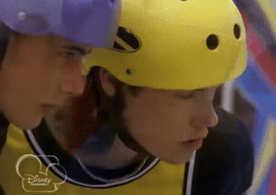 Man In Yellow Helmet Looking At Man In Purple Helmet GIF