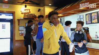 Man In Yellow Hoodie In Front Of Marsreef Sign GIF