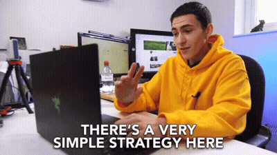 Man In Yellow Hoodie Sitting At Desk With Laptop Saying There's A Very Simple Strategy GIF