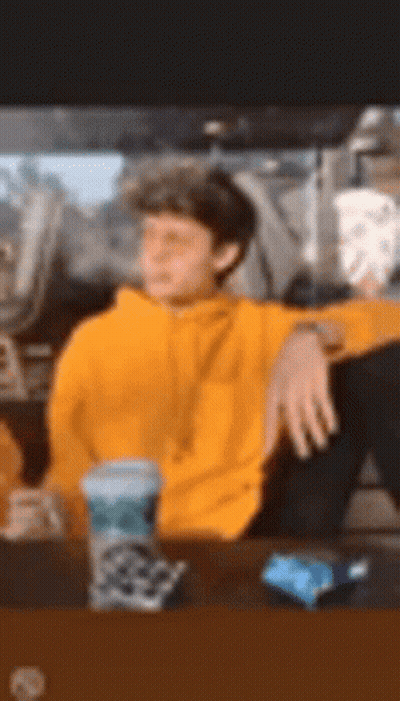 Man In Yellow Hoodie Sitting At Table GIF