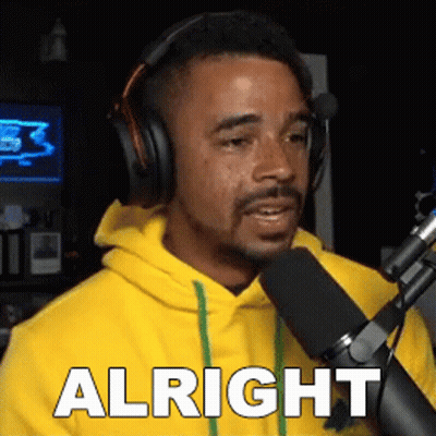 Man In Yellow Hoodie Talking Into Microphone Saying Alright GIF
