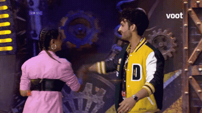 Man In Yellow Jacket D And Woman In Pink GIF