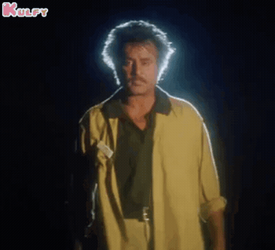 Man In Yellow Jacket Eyes Closed In Dark GIF