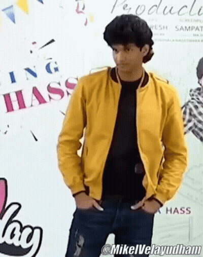 Man In Yellow Jacket In Front Of Hass Sign GIF