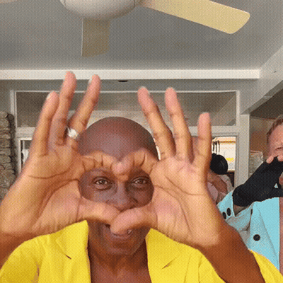 Man In Yellow Jacket Making Heart GIF