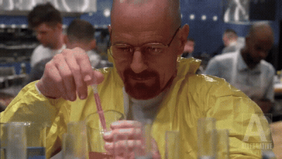 Man In Yellow Jacket Pouring Liquid Into Glass With Straw GIF