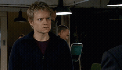 Man In Yellow Jacket Punched By Man In Brown Jacket GIF