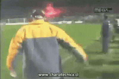 Man In Yellow Jacket Running On Soccer Field With Charlatecnica.cl GIF