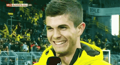 Man In Yellow Jacket Smiling Into Microphone GIF