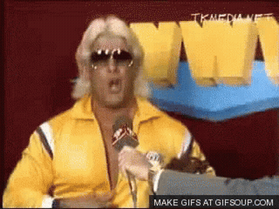 Man In Yellow Jacket Speaking Into Microphone GIF