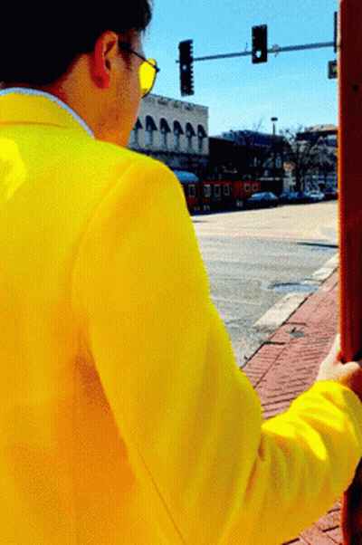 Man In Yellow Jacket Standing On Street GIF