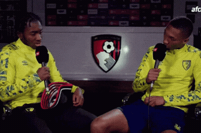 Man In Yellow Jacket Talking Into Microphone GIF