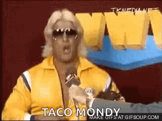 Man In Yellow Jacket Talking Into Microphone GIF