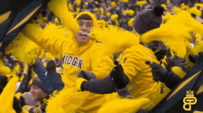 Man In Yellow Michigan Sweatshirt With Pom Poms GIF