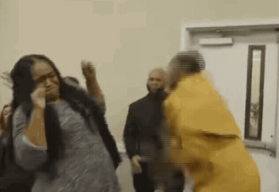 Man In Yellow Prison Uniform Next To Woman In Gray Shirt GIF