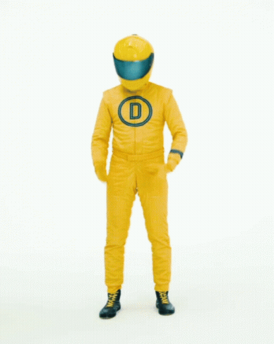 Man In Yellow Racing Suit In Front Of Done Deal Sign GIF