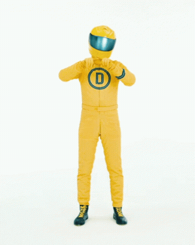 Man In Yellow Racing Suit Pointing To Pure Love GIF