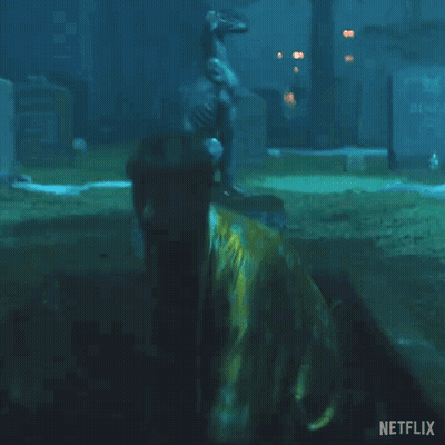 Man In Yellow Robe Holding Pole With Netflix Logo GIF