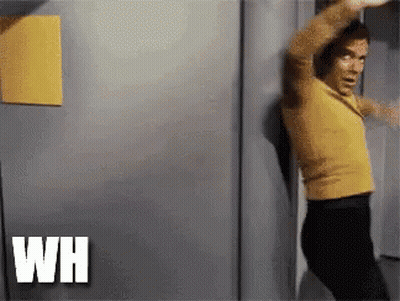 Man In Yellow Shirt And Black Pants Standing In Front Of Door GIF