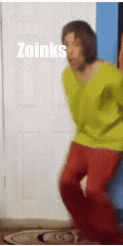 Man in Yellow Shirt and Red Pants Dancing in Front of Zoinks Door