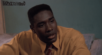 Man In Yellow Shirt And Tie Sitting By Boyz N The Hood Poster GIF