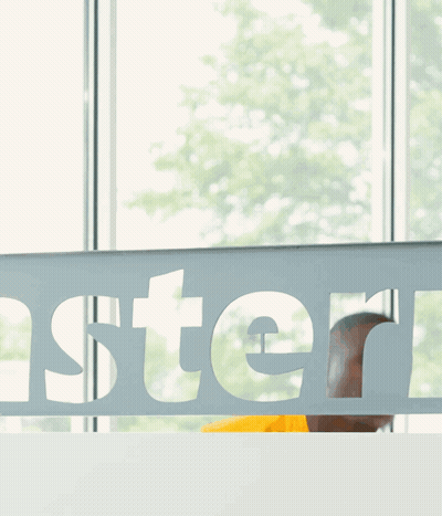 Man In Yellow Shirt Behind Oster Sign GIF