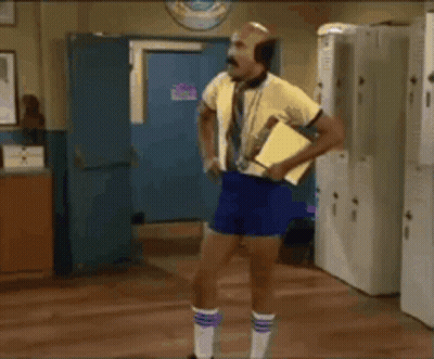 Man in Yellow Shirt Blue Shorts at Lockers Saying Son