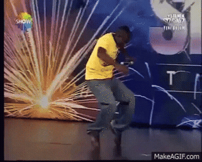 Man In Yellow Shirt Dancing In Front Of Show Wall GIF