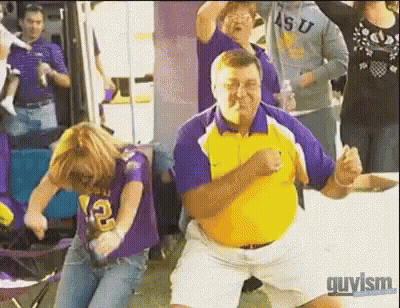 Man In Yellow Shirt Dancing With Woman In Purple Shirt Number 12 GIF